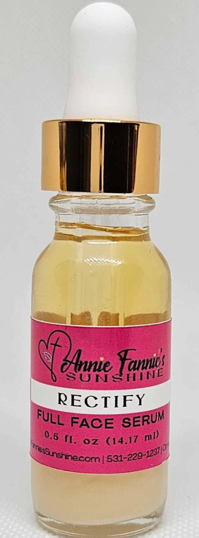 Glass serum bottle with pink label on a white background