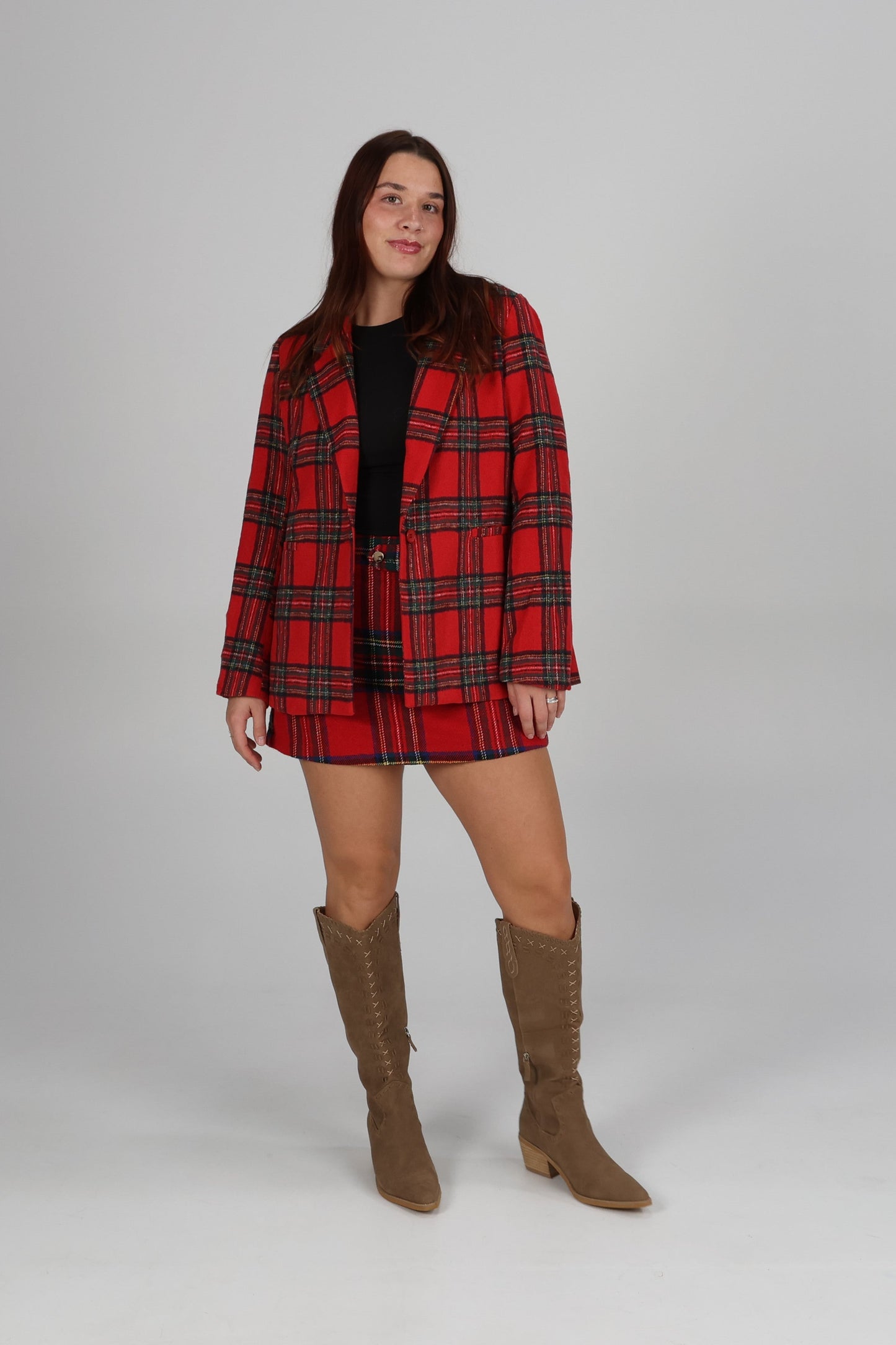 “Plaid blazer with matching shorts styled with tall brown boots — chic holiday outfit for parties and dinners.”