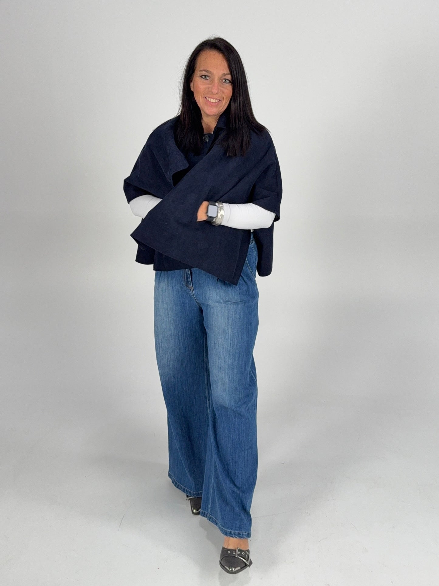 “Navy poncho layered over a white lace long sleeve top with denim — cozy casual winter boutique outfit.”